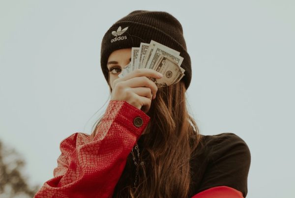 woman in black knit cap covering her face with her hand